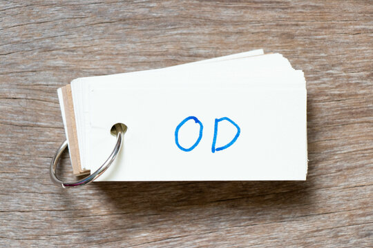 Flash card with handwriting in word OD (Abbreviation of overdraft) on wood background