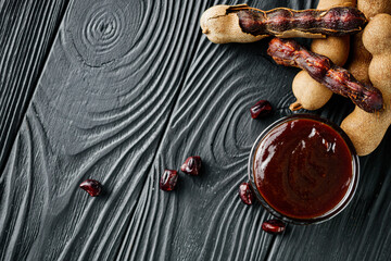 sweet and sour tamarind sauce on a black rustic wooden background