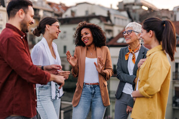 African woman talking to her colleagues, having a meeting, on the roof terrace.