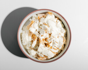 Chicken with rice and white sauce in oriental style closeup isolated top view