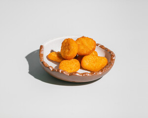 Fried chicken nuggets closeup in rustic bowl isolated