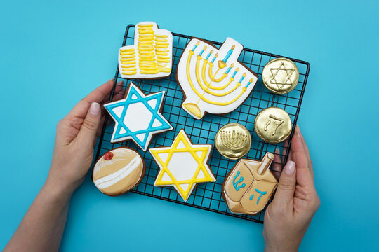 Women's hands hold a lattice with gingerbread symbols of Hanukkah.