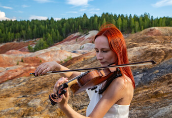 portrait with background blur a red-haired violinist playing against the background of a Martian...