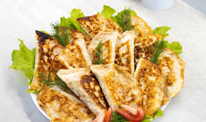 A plate with many pasties with meat. Delicious fried pasties, a traditional dish.