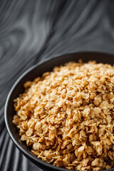 fresh raw buckwheat flakes on a black wooden background