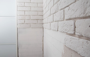White wall made of decorative stone in the form of a brick. Laying gypsum bricks during apartment renovation. Copy space for text