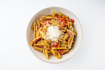 green cavatelli pasta with spinach in tomato sauce on a white background