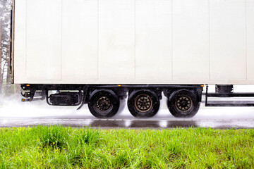 A white semi-trailer from a truck transports goods in rainy weather. Sanctions, export and import of goods. Copy space for text