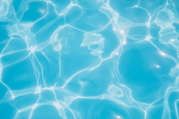 Background, blue water waves in the pool with sun reflection. Top view, selective focus