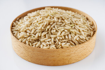 raw unpolished rice on a white acrylic background