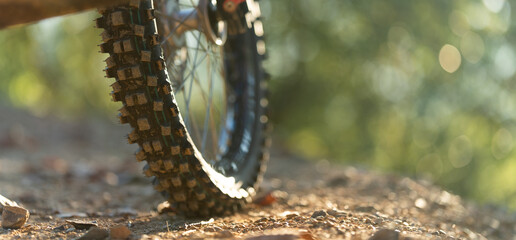 Close-up tire view. Part of a motocross wheel on a mound, with sunrise.copyspace for your...