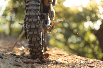 Close-up tire view. Part of a motocross wheel on a mound, with sunrise.copyspace for your...