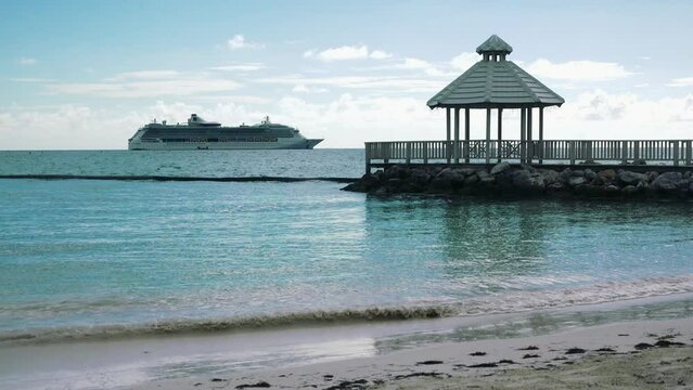 Tropical landscape with Caribbean Sea and cruise ship. Cruise ship liner sails in the blue sea. Relaxing voyage on the luxury vessel to the tropical island