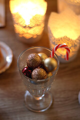 Two types of cookies, cups of tea or coffee, various Christmas decorations and lit candles. Cozy Christmas atmosphere at home. Selective focus.