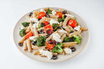 delicious penne wheat pasta with tomatoes, broccoli and mozzarella on a white background