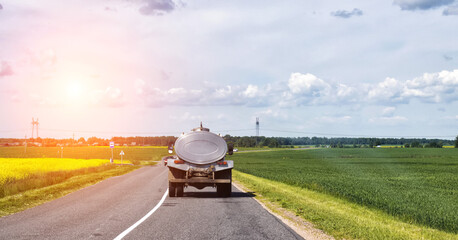 The tanker truck transports milk on the background of the fields. Logistics and business in agriculture. Copy space for text, industry, countryside