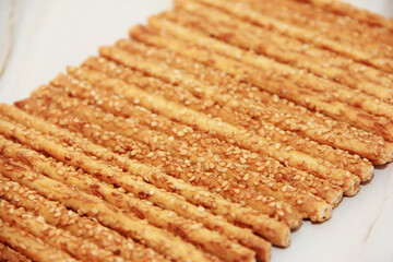 baked dry long bread sesame sticks on a marble background