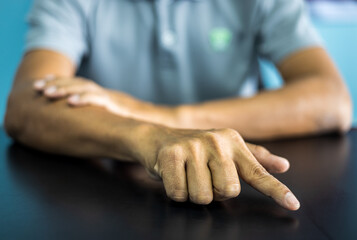 Close-up front view of both hands of a thai man wearing gray shirt making various gestures.