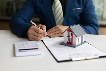 Businessman or real estate agent signs a contract to sell the house legally. Real estate consultant, legal agreement contract, rental, lease, mortgage.