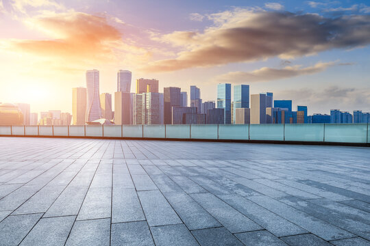 Empty square floor and city skyline with modern commercial buildings in Hangzhou at sunrise, China.