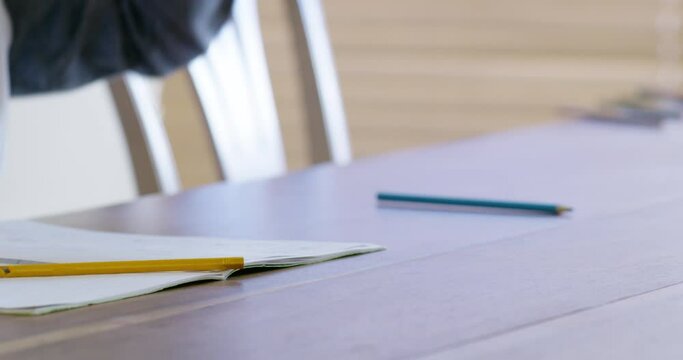 Hands, education and anger with a student throwing his pencils off a table or desk while studying. Frustrated, homework and exams with a pupil feeling stress while learning at home or in class