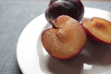 sliced fresh red plum fruit on a wooden table