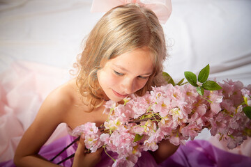 Portrait of cute kid girl posing in pink beautiful dress on a white background. Model in studio...