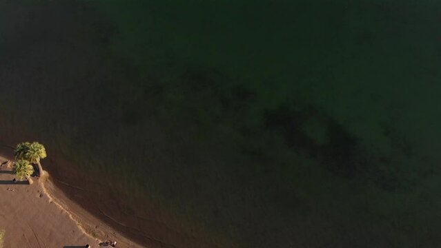 Aerial View Of The Deep Green Sea With A Sandy Beach