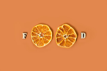 The word food from dried oranges on red background.
