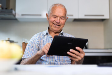 Grandfather man doing online payment from digital tablet. Elderly senior caucasian grandpa paying bills online