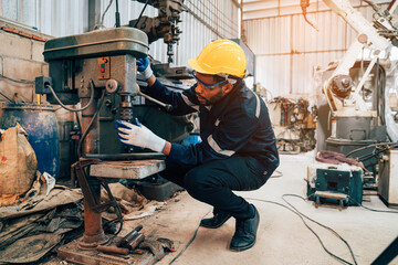 Male technician worker checking and repair pressing metal machine at factory, Machine maintenance technician operation concept.