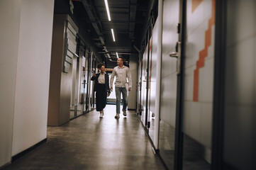 Man and woman talking walking down corridor