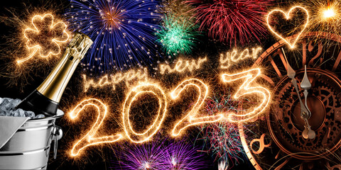 2023 sparkler number with golden clock champagne bottle in silver cooler and colorful fireworks...