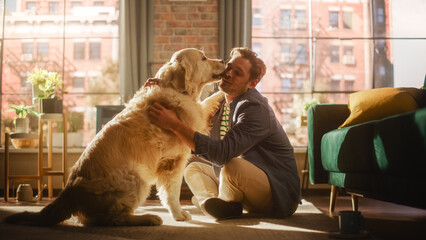 Happy Handsome Young Man Play with His Dog at Home, Gorgeous Golden Retriever. Attractive Man...