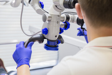 Doctor dentist or surgeon sets up a medical microscope