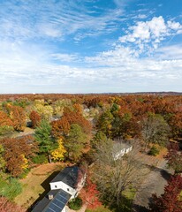 Naklejka premium Cloudy blue sky over suburban foliage scene in Longmeadow Massachusetts