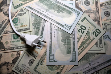 Electric power plug with USD dollars banknotes on background. Electricity cost, electric prices increase, expensive energy concept