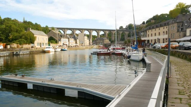 Panoramic view of the river named "Rance" in the medieval village of Dinan, Brittany, France. Several vessels and yachts at both sides. The famous bridge on the background with blue sky.