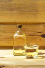 Vegetable oil in a bottle glass on the wooden background