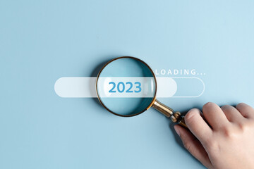 Magnifying glass focus to loading progress 2023 to countdown merry christmas and happy new year...