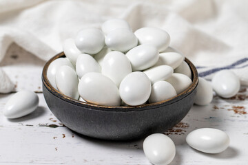 White chocolate dragee. Chocolate dragee on a white wood background. close up