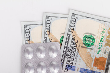 Fototapeta premium US dollars with pills. tablets packed in foil. The concept of health insurance and healthcare costs. the rise in price of medicines. price growth.