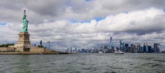 The Statue of Liberty and Manhattan in background in New York City in a cloudy day. © Ondrej Bucek