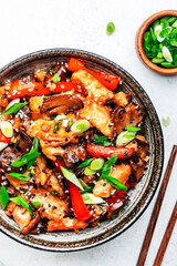 Stir fry with turkey fillet, red paprika, mushrooms, green chives and sesame seeds in bowl Asian cuisine dish. White kitchen table background, top view