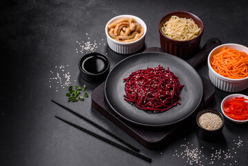 Tasty spicy Korean beet with spices and herbs on a dark concrete background