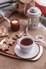 Kid takes Christmas gingerbread cookies. Atmospheric festive Christmas decorations with hot cocoa. Home coziness and warmth concept.