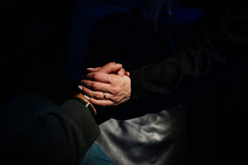 Finding love in dark places. Top view black of two lovers holding hands.