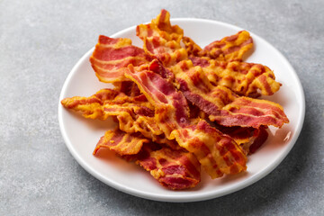 Delicious fried bacon served on plate.