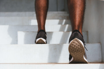 Close up athlete shoes of legs young sport runner black man step running up to climbing stairs doing training cardio sport workout at the outdoor street, healthy exercise before workout concept