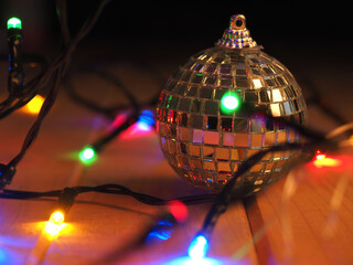 Disco ball Christmas decoration with festive lights on a wooden floor